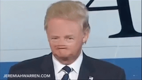 A Man In A Suit And Tie Is Making A Face . GIF
