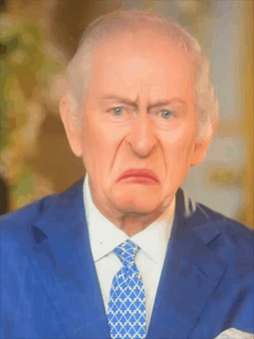 A Man In A Suit And Tie Is Making A Face GIF