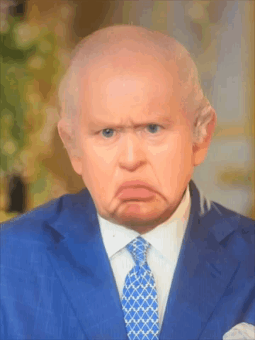 A Man In A Suit And Tie Is Making A Face GIF