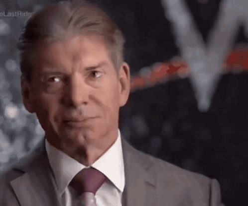 A Man In A Suit And Tie Is Making A Funny Face GIF