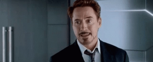 A Man In A Suit And Tie Is Making A Funny Face . GIF