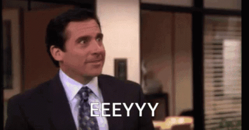A Man In A Suit And Tie Is Making A Funny Face And Saying Eeeyyy . GIF