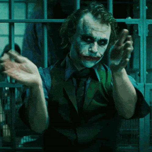 A Man In A Suit And Tie Is Making A Funny Face GIF