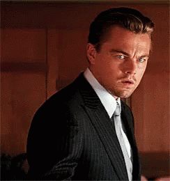 A Man In A Suit And Tie Is Making A Funny Face GIF