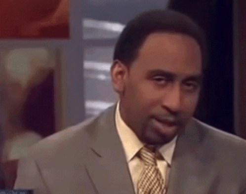 A Man In A Suit And Tie Is Making A Funny Face . GIF