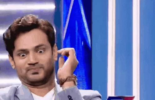 A Man In A Suit And Tie Is Making A Funny Face GIF