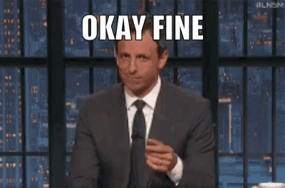 A Man In A Suit And Tie Is Making A Funny Face While Giving A Thumbs Up . GIF