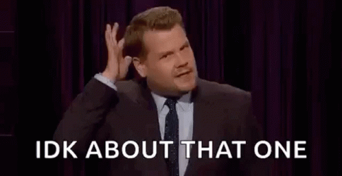A Man In A Suit And Tie Is Making A Funny Face While Talking On A Stage . GIF