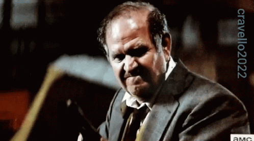 A Man In A Suit And Tie Is Making A Funny Face With A Watermark That Says Orvello2022 GIF