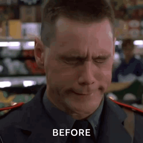 A Man In A Suit And Tie Is Making A Funny Face With His Eyes Closed And The Words Before Written On The Bottom . GIF