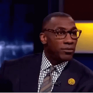 A Man In A Suit And Tie Is Making A Funny Face With His Mouth Open . GIF