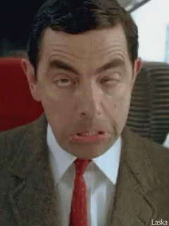 A Man In A Suit And Tie Is Making A Funny Face With His Mouth Open . GIF