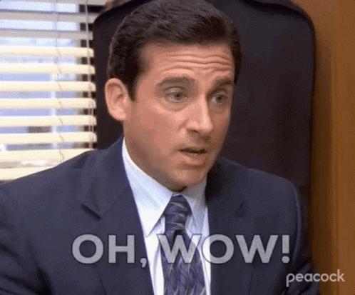 A Man In A Suit And Tie Is Making A Surprised Face And Saying Oh Wow . GIF