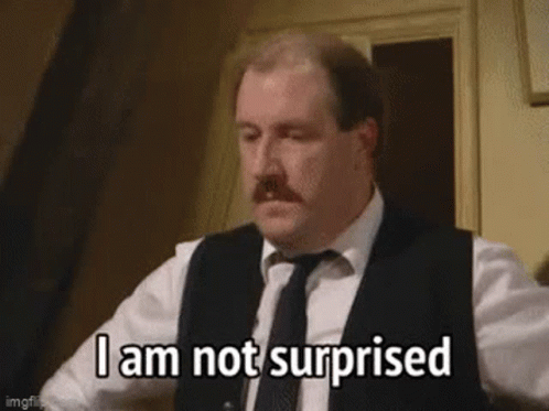 A Man In A Suit And Tie Is Making A Surprised Face . GIF