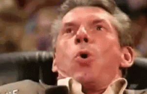 A Man In A Suit And Tie Is Making A Surprised Face With His Mouth Open . GIF