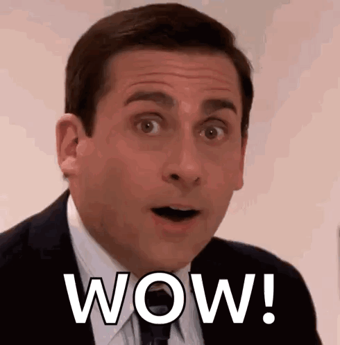 A Man In A Suit And Tie Is Making A Surprised Face With The Word Wow Written On His Face . GIF