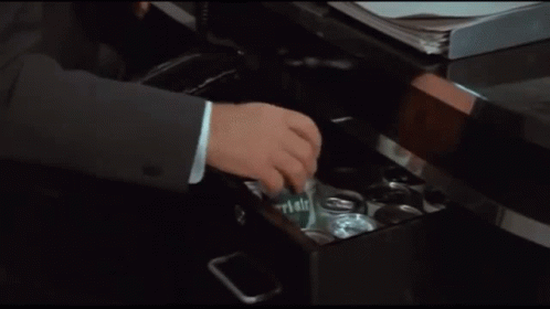 A Man In A Suit And Tie Is Opening A Can Of Beer GIF