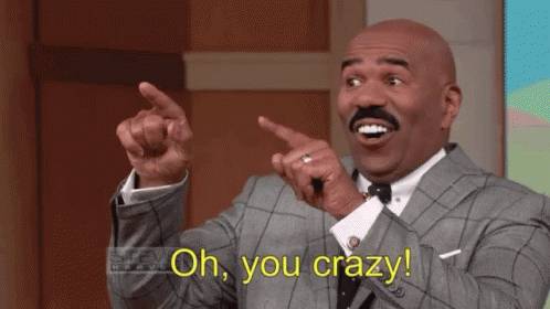 A Man In A Suit And Tie Is Pointing At Something And Saying Oh You Crazy GIF