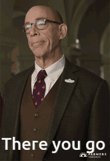 A Man In A Suit And Tie Is Pointing At Something With The Words There You Go Below Him GIF