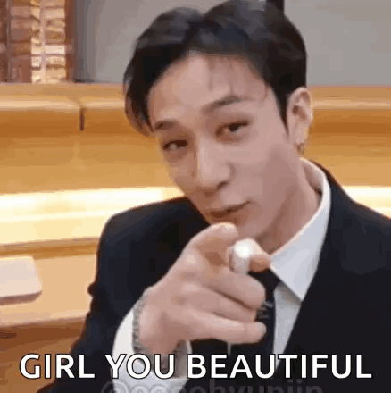 A Man In A Suit And Tie Is Pointing At The Camera While Saying `` Girl You Beautiful '' . GIF