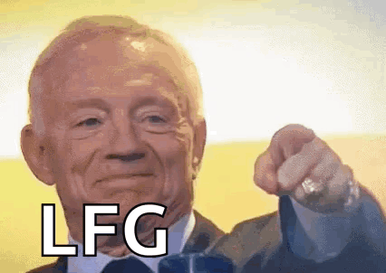 A Man In A Suit And Tie Is Pointing At The Camera With The Word Lfg On His Face . GIF
