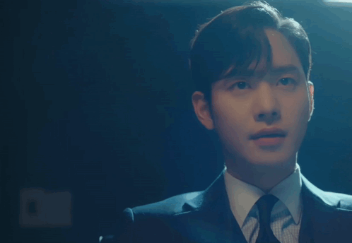 A Man In A Suit And Tie Is Pointing His Finger At Something GIF