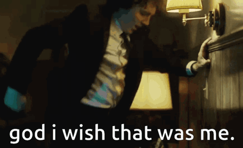 A Man In A Suit And Tie Is Reaching For A Lamp With The Words God I Wish That Was Me Written Below Him GIF