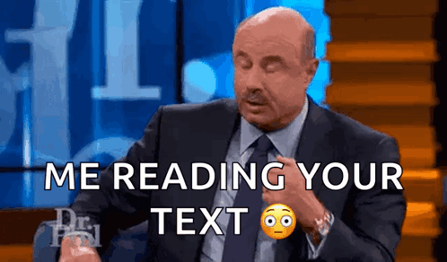 A Man In A Suit And Tie Is Reading A Text GIF