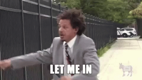 A Man In A Suit And Tie Is Running Down A Sidewalk And Says `` Let Me In '' . GIF