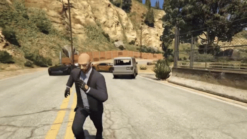 A Man In A Suit And Tie Is Running Down The Road GIF