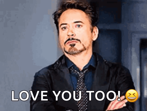 A Man In A Suit And Tie Is Saying I Love You Too . GIF