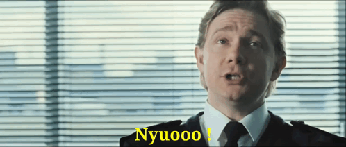 A Man In A Suit And Tie Is Saying Nyuoo GIF
