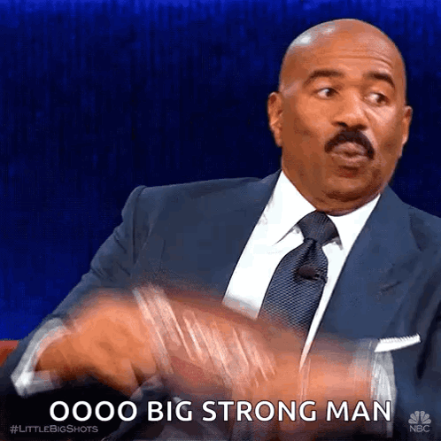 A Man In A Suit And Tie Is Saying " Oooo Big Strong Man " . GIF