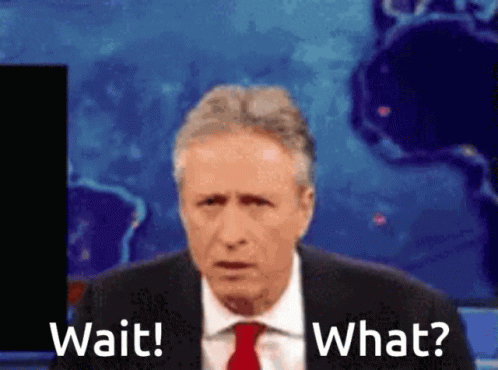 A Man In A Suit And Tie Is Saying Wait And What GIF