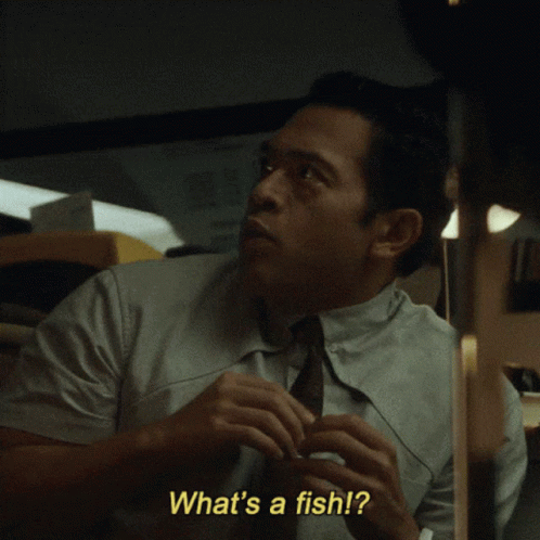 A Man In A Suit And Tie Is Saying What 'S A Fish GIF
