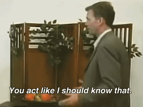 A Man In A Suit And Tie Is Saying You Act Like I Should Know That GIF