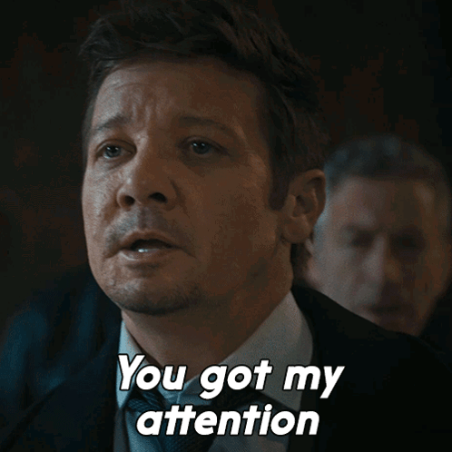 A Man In A Suit And Tie Is Saying " You Got My Attention " GIF