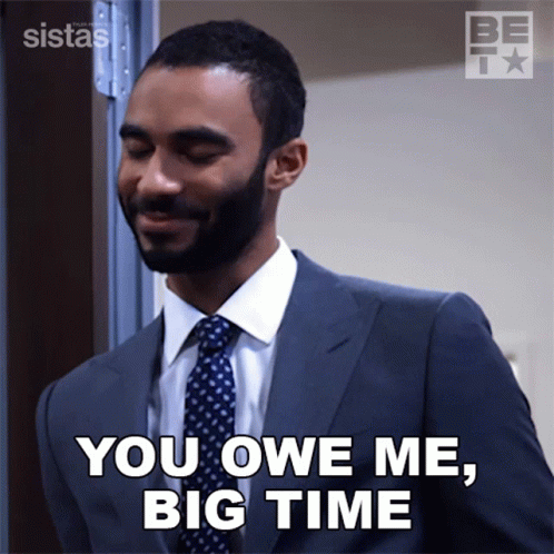 A Man In A Suit And Tie Is Saying You Owe Me Big Time GIF