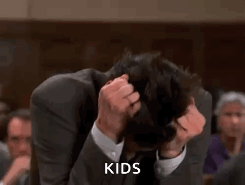 A Man In A Suit And Tie Is Scratching His Head And The Word Kids Is Visible . GIF