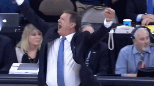 A Man In A Suit And Tie Is Screaming In The Stands GIF