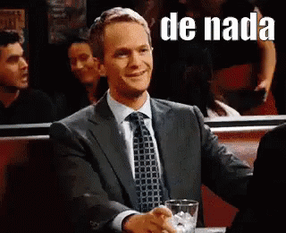 A Man In A Suit And Tie Is Shaking Hands With Another Man In A Restaurant . GIF