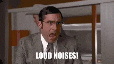 A Man In A Suit And Tie Is Shouting Loud Noises While Wearing A Headset . GIF