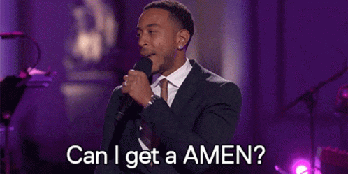 A Man In A Suit And Tie Is Singing Into A Microphone And Asking Can I Get A Amen . GIF
