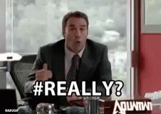 A Man In A Suit And Tie Is Sitting At A Desk And Saying Really ? GIF