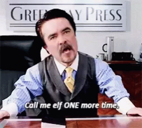 A Man In A Suit And Tie Is Sitting At A Desk And Says Call Me Elf One More Time GIF