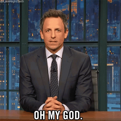 A Man In A Suit And Tie Is Sitting At A Desk And Says Oh My God GIF
