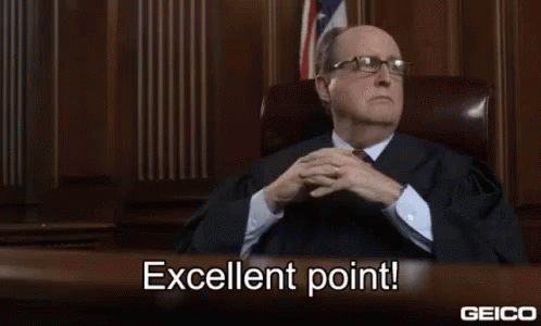 A Man In A Suit And Tie Is Sitting At A Desk In A Courtroom And Says Excellent Point . GIF