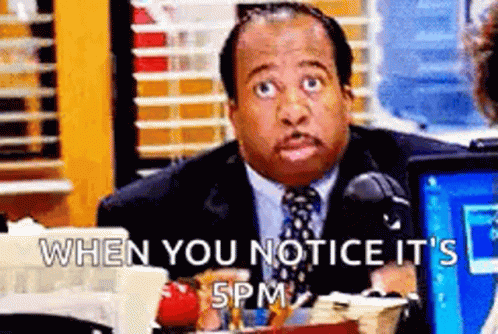 A Man In A Suit And Tie Is Sitting At A Desk In Front Of A Computer Screen . GIF
