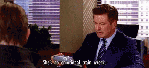 A Man In A Suit And Tie Is Sitting At A Desk With A Woman . GIF
