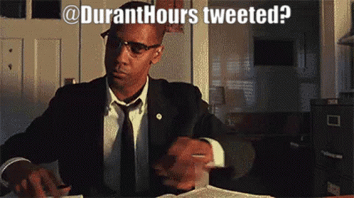 A Man In A Suit And Tie Is Sitting At A Desk With The Words " Duranthours Tweeted " Written Above Him GIF